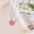 Detail of pink heart-shaped couple necklaces with For ever engraving and floral background - Pink