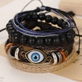 Detailed close-up of multi-layer leather bracelets set with evil eye charm on vintage paper - Evil Eye Enamel Pendant (BN-0129-24)