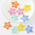 Colorful star-shaped metal hair clips in various bright matte finishes on a white tray - Solid Color Star