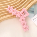 Détail d'une pince à cheveux rose macaron en forme d'étoile sur plateau bois - Rose
