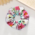Détail du chouchou floral coloré avec bords violets et texture de tissu élastique - Imprimé Lettres Tie Dye Multicolore