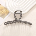 Primer plano de pinza de pelo en metal gris plomo con textura de cadena y strass oscuros - Estilo Plata Oscura Cadena Diamante