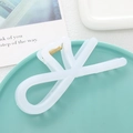 Elegant white translucent bow hair claw clip with gold spring on a decorative plate - Jelly White