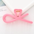 Detailed macro view of a pink heart-shaped hair claw clip with golden metal spring - Pink