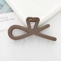 Detail view of a brown heart-shaped hollow hair clip on a minimalist white background - Dark Coffee