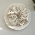 Elegante elastico scrunchie bianco a pois su un piatto di ceramica con luce naturale - Bianco Sporco