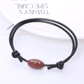 Verstelbare zwarte gevlochten armband met een bruine American football-harskraal - Rugby Stijl