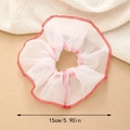 Détail d'un chouchou en tulle blanc de 15 cm avec bords cousus rouges sur fond texturé - Rouge