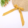 Detail of a silky ginger yellow double-layered ribbon bow hairclip with long tails - Orange