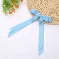 Detail view of light blue satin double bow hair clip with elegant long streamers - Sky Blue