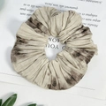 Macro detail of French vintage scrunchie featuring ink flower pattern and pleated texture - Gradient Khaki