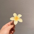 Détail d'une pince à cheveux frangipanier jaune avec une texture en résine translucide - Jaune