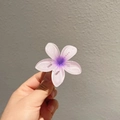 Détail d'une pince à cheveux fleur dégradé violette tenue à la main pour l'échelle - Violet