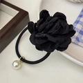 Detail of a black fabric layered flower hair tie with an elegant white pearl pendant charm - Black