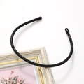 Detailed close-up of a slim headband featuring high-quality black rhinestones and soft tips - Black
