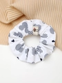 Primo piano di scrunchie bianco con motivi blu e dettaglio etichetta tessuta orso - Scrunchie a Quadri Bianco