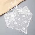 Dettaglio foulard in pizzo bianco con ricami floreali e bordi smerlati con pompon - Stile Pizzo Mughetto