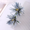 Detailopname van twee blauwe stoffen chrysant haarspelden op een witte achtergrond - Blauw