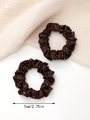 Detail view of coffee-colored satin scrunchies with rhinestones and 7cm size marking - Brown