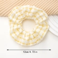 Détail d'un chouchou à carreaux jaunes montrant la texture du tissu et la taille de 12cm - Jaune