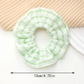Detail van groen-witte geblokte scrunchie met zachte seersucker textuur en maat van 12 cm - Groen