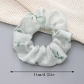 Gedetailleerd zicht op bloemen organza scrunchie van 11 cm met groene bladpatronen - Groen
