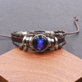 Detailweergave van de geweven leren Steenbok-armband met lichtgevende glazen koepel en koord - Steenbok