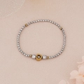 Detailed shot of silver faceted beads with a gold hollow heart pendant on a textured surface - Silver Faceted Beads with Gold Heart Pendant Style (BNS-0217-2)