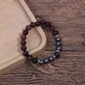 Detailed macro view of 8mm red tiger eye beads and hematite stones on a beaded bracelet - Red Tiger Eye