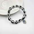 Nahaufnahme von Hamsa-Hand-Anhänger mit blauem Auge und gemusterten Perlenarmband - Schwarzer Handstil (BNS-0222-10mm)