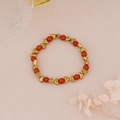 Detail of beaded bracelet with red beads and golden triangle accents on pink background - Dark Red Beads with Gold Triangle Spacers Style (BNS-0217-3)