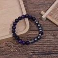 Detailed macro of 8mm purple tiger eye and hematite beaded bracelet on wooden tray - Purple Tiger Eye