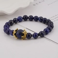 Macro view of Lapis Lazuli beads with a golden crown charm on a luxury men's bracelet - Lapis Lazuli