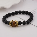 Detail of matte black beads with tiger eye stone and golden crown spacers on a bracelet - Black Agate and Tiger Eye