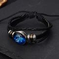 Detail of multi-layer leather bracelet featuring a luminous Virgo zodiac glass charm - Virgo