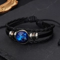 Macro detail of hand-braided leather bracelet featuring Cancer zodiac sign and glass charm - Taurus