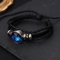 Vue macro d'un bracelet en cuir multicouche avec pendentif dôme en verre zodiaque lumineux - Cancer