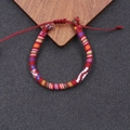 Nahaufnahme eines handgefertigten Boho-Armbandes mit roter Basis und bunten Mustern - Tiefrot/Bunt (5)