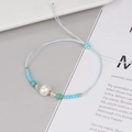 Bracciale intrecciato azzurro fatto a mano con perla d'acqua dolce e cordino regolabile - Blu