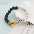 Detail of beaded dragon bracelet with lava stone, tiger eye, and engraved metal dragon heads - Black And White Turquoise