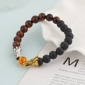 Beaded dragon bracelet with tiger eye stones and lava rock on a decorative ceramic tray - Black And Red Tiger Eye