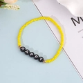 Dettaglio del braccialetto di perline gialle con lettere nere Happy e accenti dorati - Stile HAPPY / Giallo (BN-0157 Giallo)