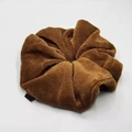 Macro-opname van een grote donkerbruine pluche scrunchie met zachte flanellen textuur - Bruin