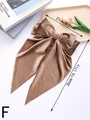 Detalle de una pinza para el pelo con lazo de terciopelo marrón y cintas largas con textura - Camel