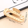 Minimalist gold-plated hair claw clip with liquid metal texture and hollow design - Gold