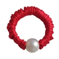 Close-up of a red satin scrunchie with a large decorative white pearl accessory - Red
