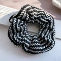 Detaillierte Makroansicht der schwarz-weißen Strickstruktur des großen Haargummi-Scrunchies - Schwarz
