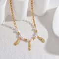 Detailed macro shot of 18K gold necklace featuring white pearls and feather pendants - Feather