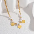 Detail of 18K gold chain necklace with white pearls and three hanging heart pendants - Heart