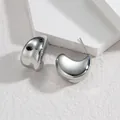 Makroaufnahme silberner C-förmiger Titanstahl-Ohrringe mit polierter Spiegeloberfläche - Silber